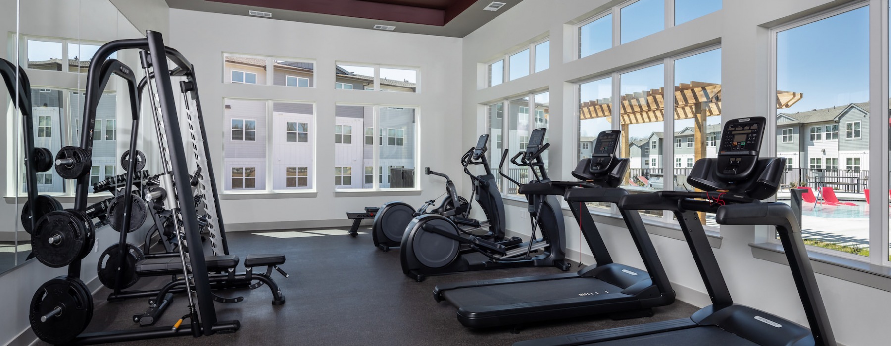 fitness center with treadmills and windows overlooking the pool